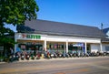 White retro facade building of 7 eleven convenience stores with a row of motorcycles at the front.